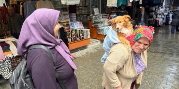 TRABZON SOKAKLARININ EN SIRA DIŞI GEZİNTİSİ BATTANİYEYE SARIP SIRTINA ALDIĞI 'KUKULİ' İSİMLİ KÖPEĞİ İLE İZİN GÜNLERİNDE TRABZON'U SOKAK SOKAK GEZİYOR TRABZONLU PAKİZE HATİPOĞLU, SOKAKLARDA SIRTINDA TAŞIDIĞI 'KUKULİ' İSİMLİ KÖPEĞİ İLE DOLAŞARAK YÜREKLERİ ISITIYOR